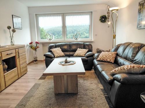 a living room with a leather couch and a coffee table at Apartment Marie by Interhome in Schieder-Schwalenberg