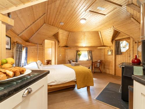 a bedroom in a log cabin with a bed at Apartment Ghillie's Bothy by Interhome in Coldstone