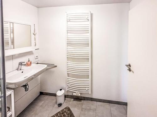 a white bathroom with a sink and a mirror at Apartment Marie by Interhome in Schieder-Schwalenberg