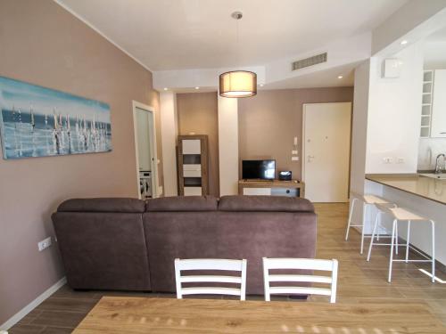 a living room with a brown couch and white chairs at Apartment Sibilla by Interhome in Intra