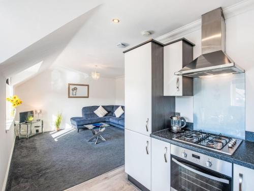 a kitchen with a stove and a living room at Apartment Varis Haven by Interhome in Forres