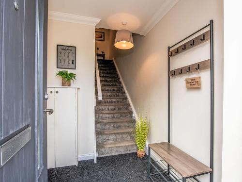 a hallway with stairs and a door with a mirror at Apartment Varis Haven by Interhome in Forres