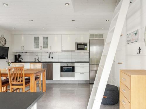 a kitchen with white cabinets and a wooden table at Holiday Home Östra Stranden by Interhome in Larsfrid