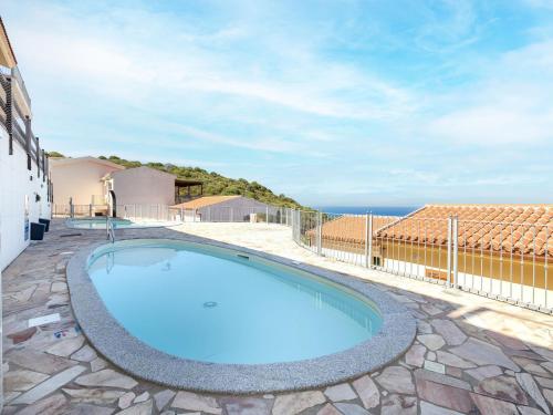 a swimming pool in the middle of a patio with the ocean at Apartment Vista Paradiso by Interhome in Cascabraga