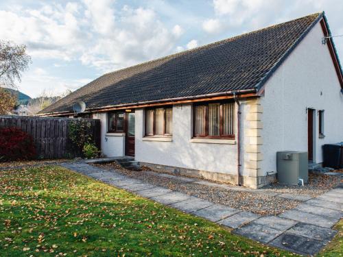 a white house with a black roof at Holiday Home Coiltie House by Interhome in Drumnadrochit