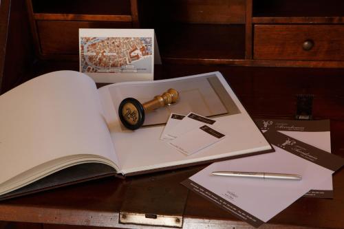 an open book with a cannon and a pen on a table at Pensione Accademia - Villa Maravege in Venice