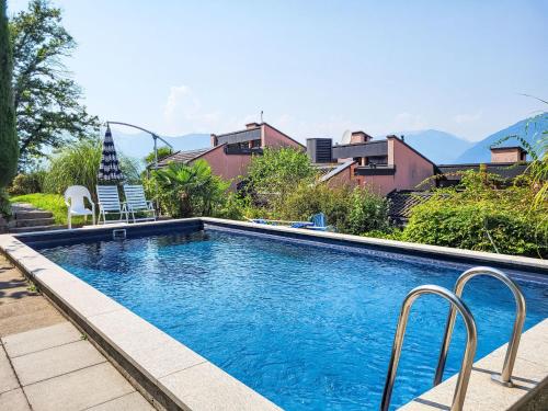 Monte CeneriにあるApartment La Perla by Interhomeの家の隣に椅子2脚付きのスイミングプール