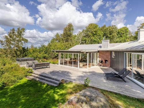 a house with a deck with a bench on it at Holiday Home Utsikten by Interhome in Grimsholmen