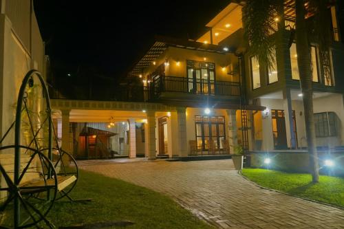 un edificio con una palmera delante de él por la noche en Rayyan Villa, en Kalutara