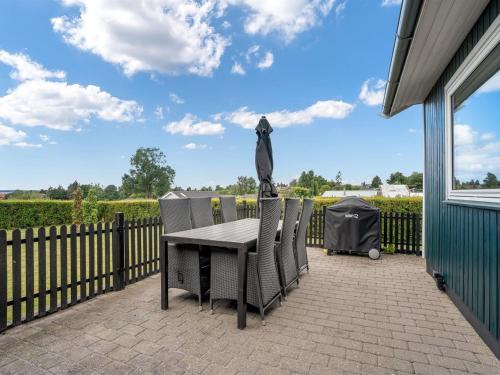 a table and chairs on a patio with a fence at Holiday Home Panu - 2-1km from the sea by Interhome in Bogø By