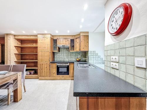 a kitchen with a red clock on the wall at Chalet Chalet La Bergerie by Interhome in Les Brévières