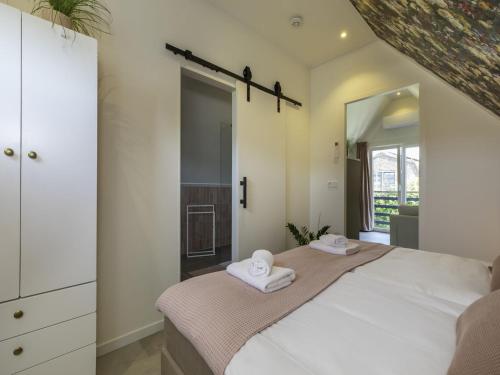 a bedroom with a large bed with towels on it at Apartment Appartement 'Bed by Al' by Interhome in Kortgene