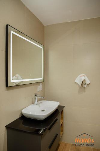 a bathroom with a sink and a mirror at Momo's Guest House in Kumasi