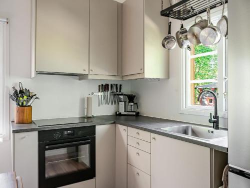 a kitchen with white cabinets and a sink at Holiday Home Stenlycke by Interhome in Ivö