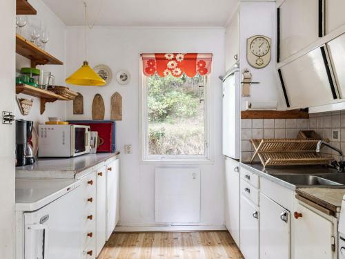 a kitchen with white cabinets and a window at Holiday Home Frösakull by Interhome in Frösakull