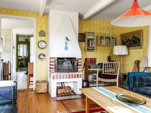 a living room with yellow wallpaper and a fireplace at Holiday Home Frösakull by Interhome in Frösakull