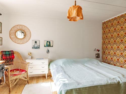 a bedroom with a bed and a chair at Holiday Home Frösakull by Interhome in Frösakull