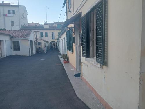 een leeg steegje met groene luiken op een gebouw bij Villa Voltina in Livorno