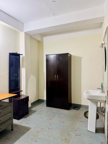 a bathroom with a black door and a sink at Maria's Homestay in Siliguri