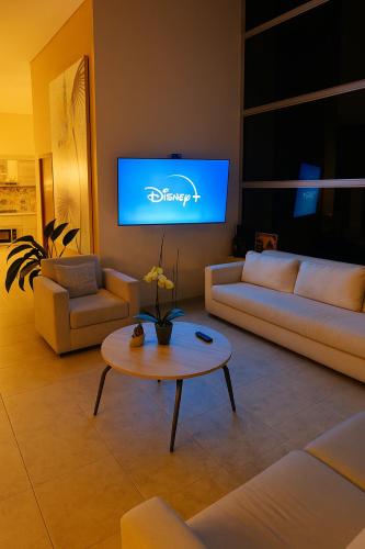 a living room with couches and a tv on the wall at Casa Campestre - Pet Friendly - Green Energy in Anapoima