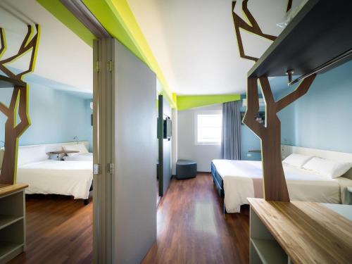 a hotel room with two beds and a hallway at ibis Styles Curitiba Centro Civico in Curitiba