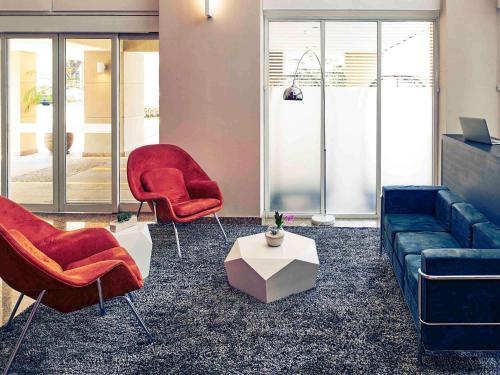 a living room with two chairs and a couch at Mercure Sao Paulo Vila Olimpia in São Paulo