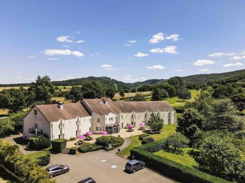 an aerial view of a mansion with cars parked in a parking lot at Hotel ibis Autun in Autun