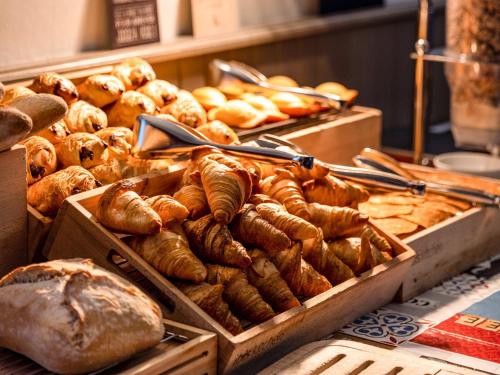 a display of bread and pastries in boxes on a table at Hotel ibis Autun in Autun