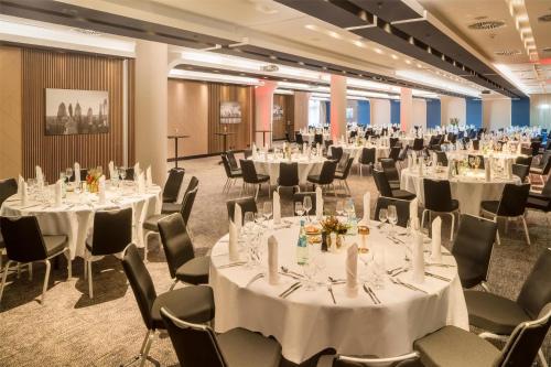 a conference room with tables and chairs with white tablecloths at Radisson Blu Hotel, Hamburg in Hamburg