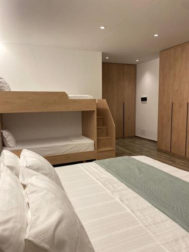 a bedroom with a large white bed and a shelf at Nettuno Resort Orikum in Orikum