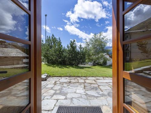 une porte ouverte avec vue sur la cour dans l'établissement Chalet Baita Emet by Interhome, à Casone