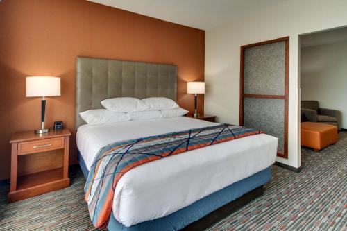 a hotel room with a large bed and a chair at Drury Inn & Suites Knoxville West in Knoxville