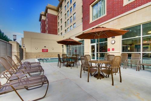 an outdoor patio with tables and chairs and umbrellas at Drury Inn & Suites Knoxville West in Knoxville