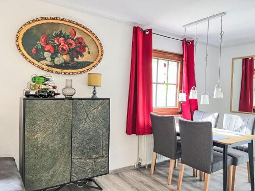 a dining room with a table and red curtains at Holiday Home Ferienhaus Inge & Henry an der Werra by Interhome in Altenburschla