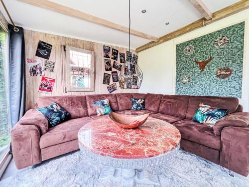 a living room with a brown couch and a table at Holiday Home Ferienhaus Inge & Henry an der Werra by Interhome in Altenburschla