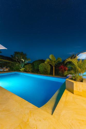 a blue swimming pool at night at Casa Campestre - Pet Friendly - Green Energy in Anapoima