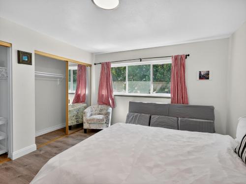 a bedroom with a bed and a chair and a window at Coastal Escape with Private Mini Golf home in Hollywood Beach