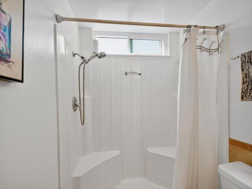 a white bathroom with a shower and a window at Coastal Escape with Private Mini Golf home in Hollywood Beach