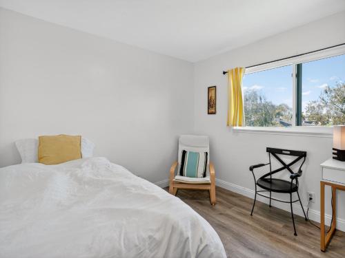 a bedroom with a bed and a chair and a window at Coastal Escape with Private Mini Golf home in Hollywood Beach