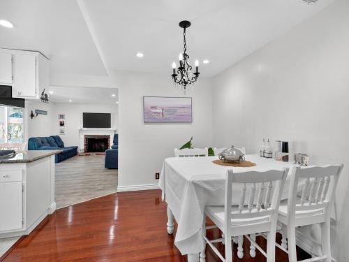 a kitchen and dining room with a white table and chairs at Coastal Escape with Private Mini Golf home in Hollywood Beach