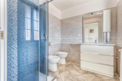 a bathroom with a toilet and a glass shower at Elegante Appartamento con Comfort Completi vicino a Mezzi & Servizi in Bareggio