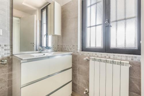 a bathroom with a sink and a mirror at Elegante Appartamento con Comfort Completi vicino a Mezzi & Servizi in Bareggio