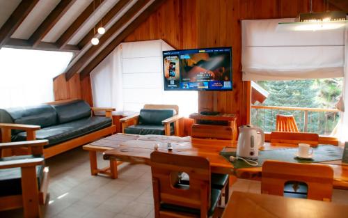 a living room with a television and a table and chairs at Sol y Nieve in San Martín de los Andes