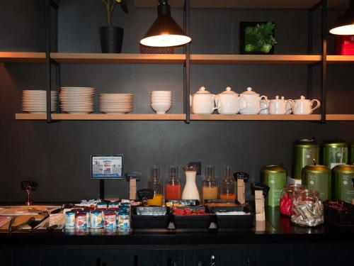 a counter top with plates and vases on it at Mercure St Malo Front de Mer in Saint Malo