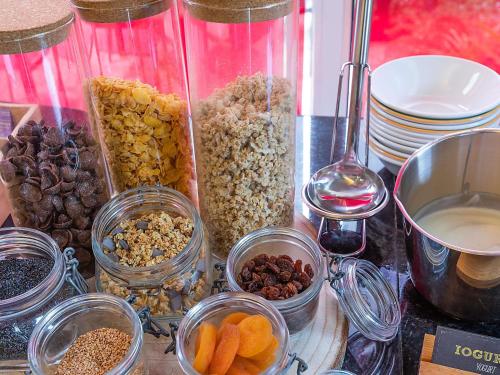 a bunch of different types of food in glass jars at Hotel ibis Guimaraes in Guimarães