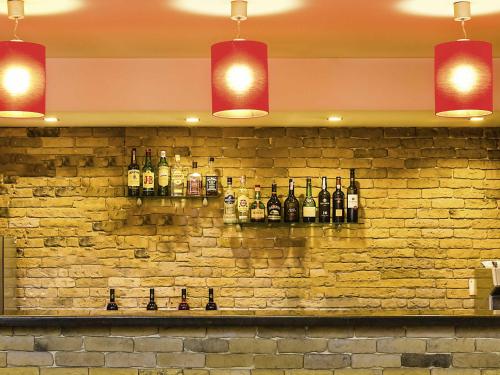 a wall with bottles of alcohol on a brick wall at Hotel ibis Guimaraes in Guimarães
