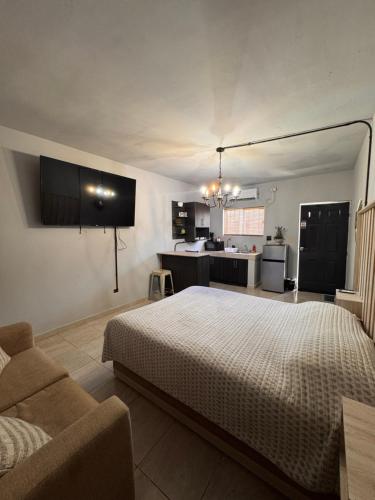 a bedroom with a bed and a couch and a kitchen at Estancias Nava #6 in San Antonio