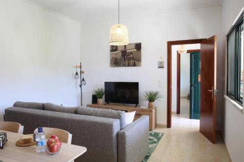 a living room with a couch and a tv at Villa Rosa in Corroios