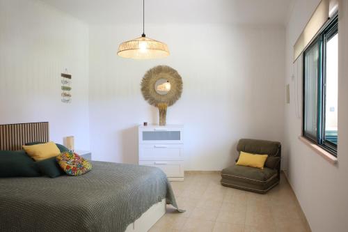 a bedroom with a bed and a chair at Villa Rosa in Corroios