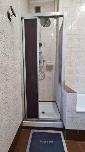a shower with a glass door in a bathroom at Dock Bay Lodge Hostel in Trieste